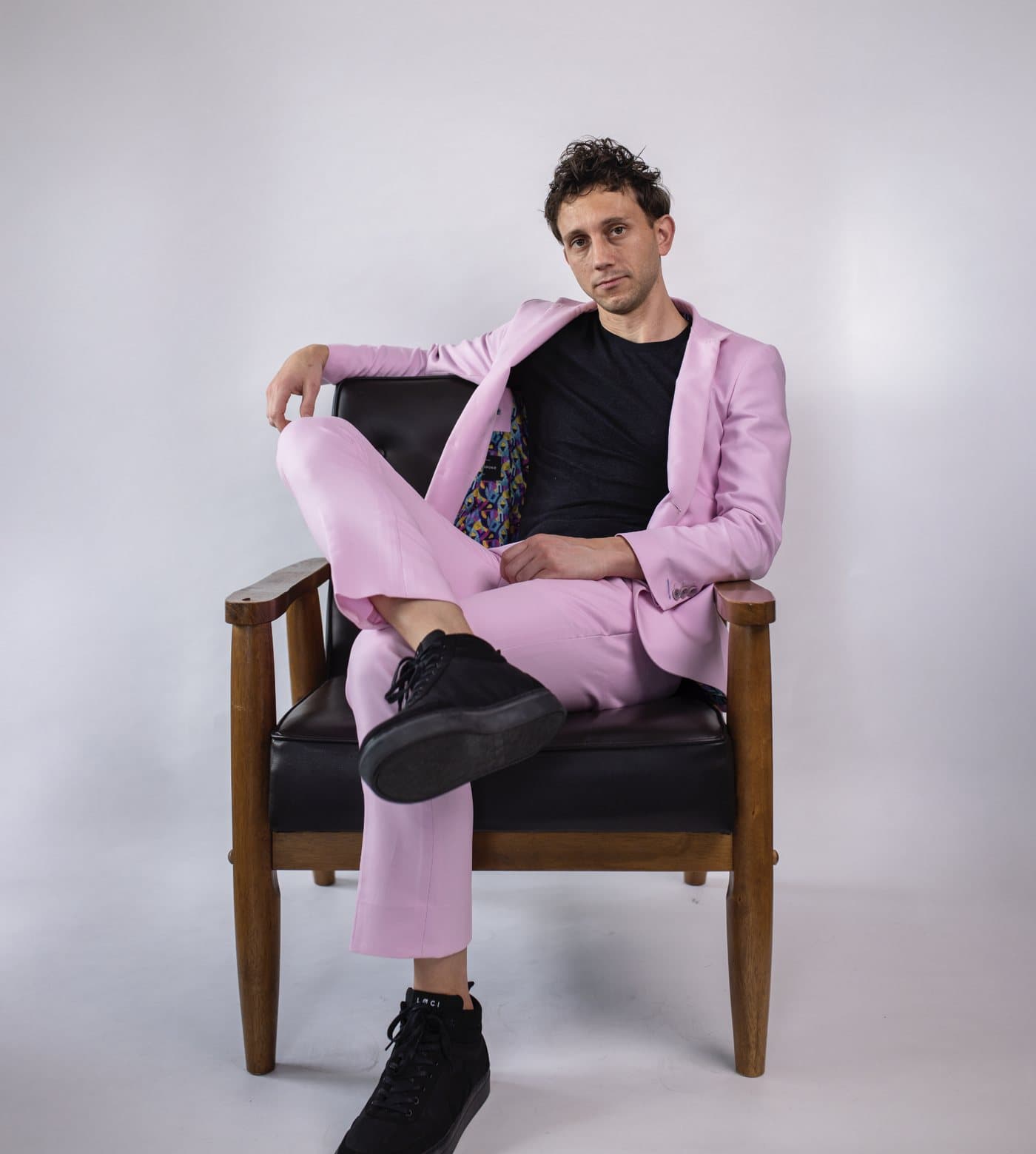 Mark Warnick seated in a pink suit
