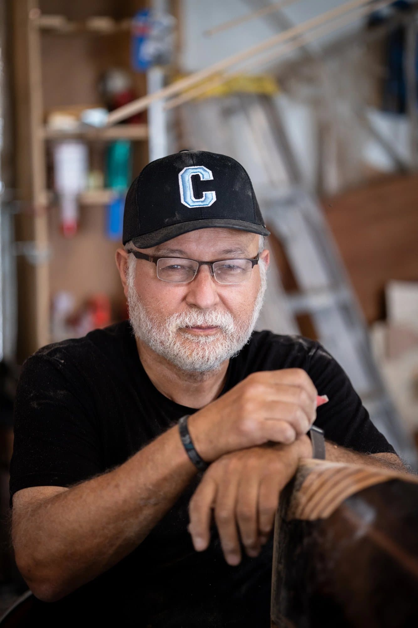 Carlos Becerra, featured in Volume 38, in glasses and a black C cap in his workshop.