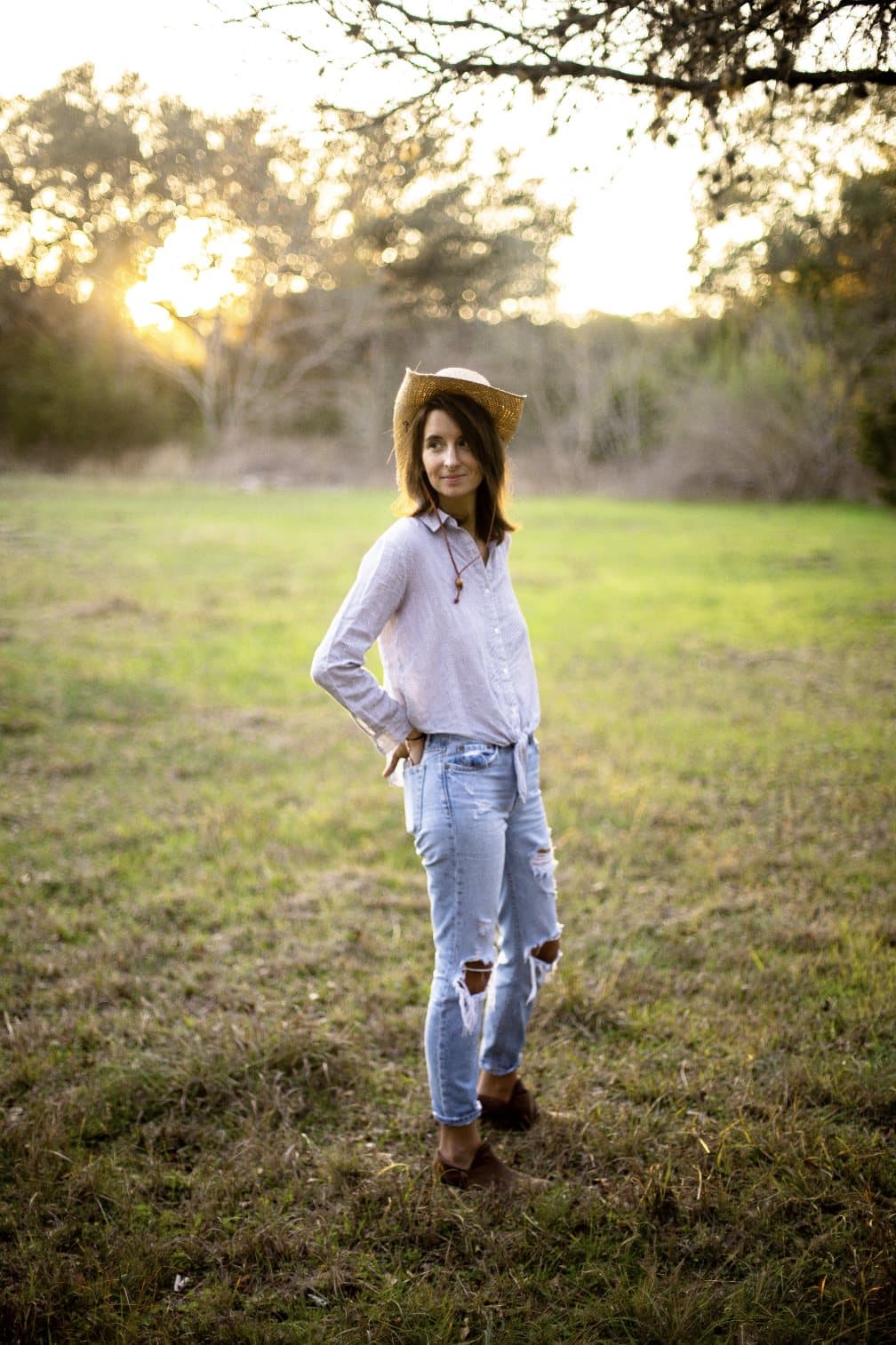 Eileen Lamb, featured in Volume 34, in a straw hat standing in a grassy field at sunset.