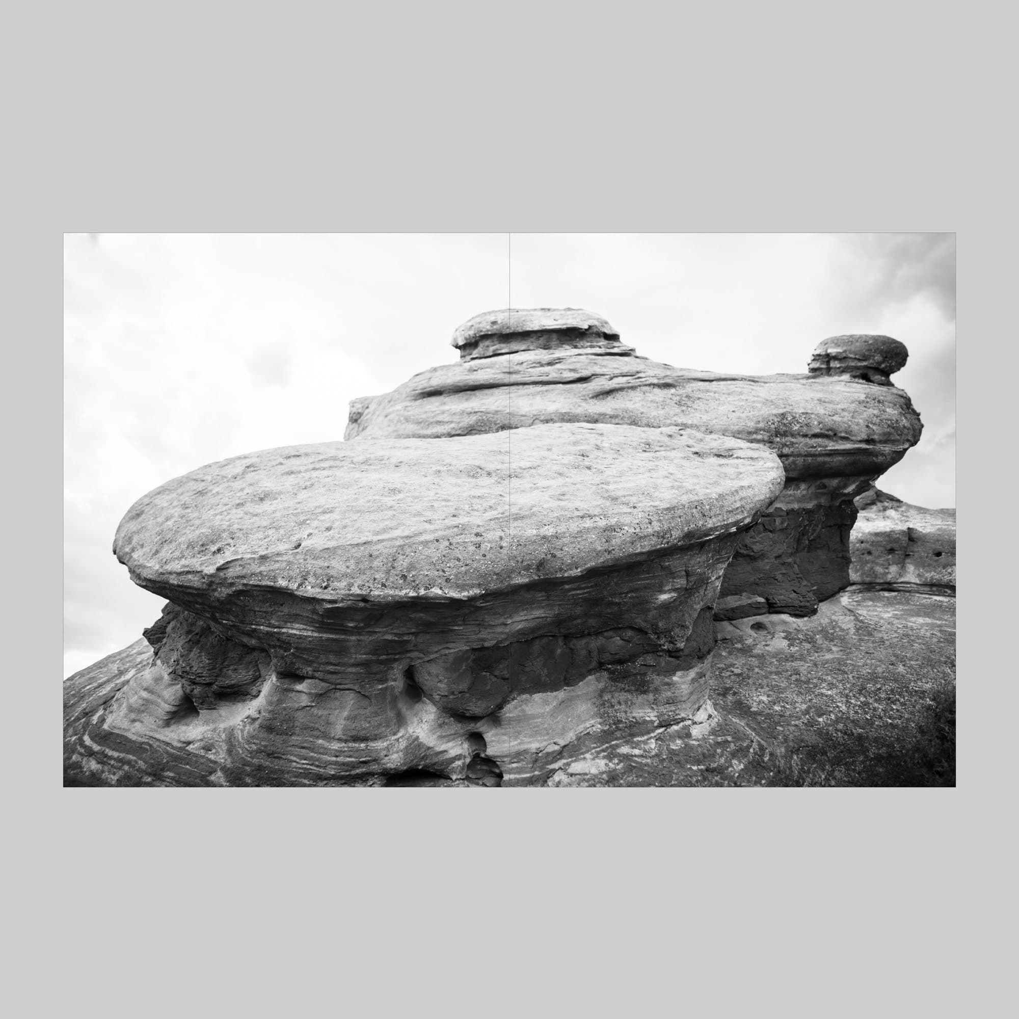 Spread from Volume 38 with a full-bleed black and white photo of layered rock formations.