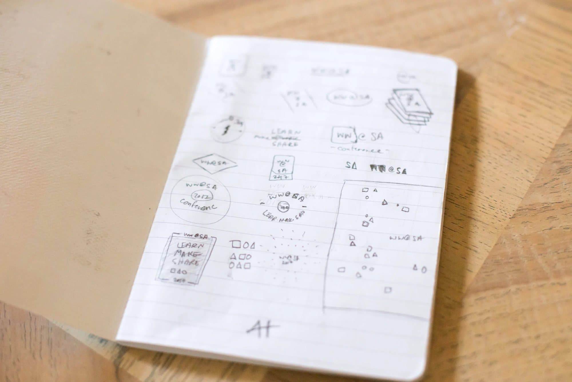 An open sketchbook of pencil concepts for the WW@SA ticket banner and logo.