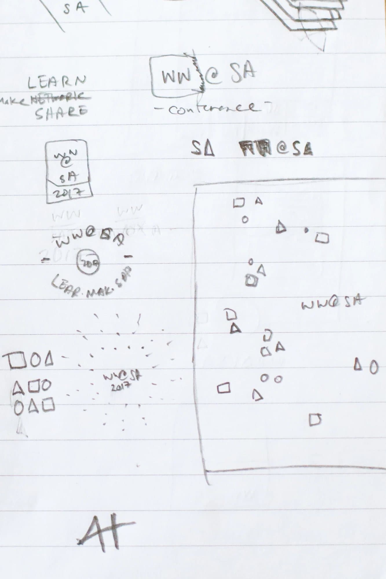 Close view of pencil sketches for WW@SA marks, the tagline, and a banner of scattered shapes.